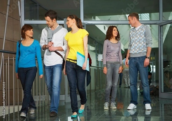 Fototapeta University students walking in corridor