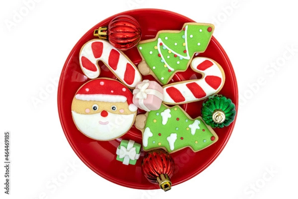 Fototapeta Sugar coated cookies on a bright red plate with Christmas decorations.