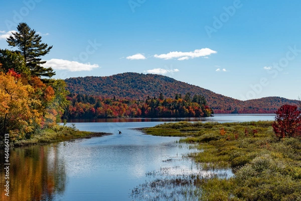 Obraz Autumn landscape in the Adirondack Mountains with a canoe traveling into Lewey Lake