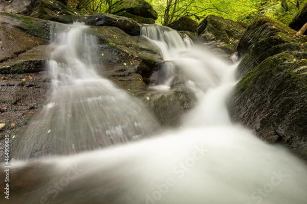 Fototapeta Long exposure of a waterfall on the Hoar Oak Water river flowing through the woods at Watersmeet in Exmoor National Park