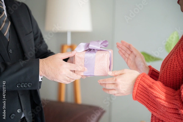 Fototapeta Close-up of the hand in a portrait of a couple giving a gift.