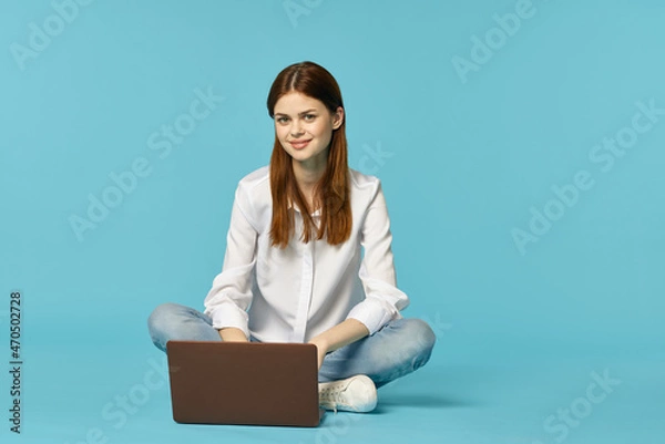 Fototapeta woman with laptop learning internet online education blue background