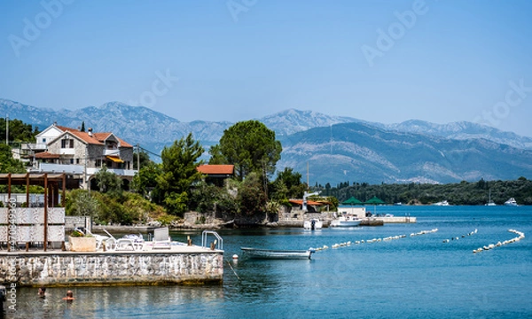 Fototapeta Beautiful Mediterranean architecture in Montenegro from Adriatic sea view. Scenic town with mountains on background