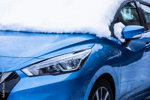 Fototapeta Blue car covered in snow. Winter morning. Snowy road.