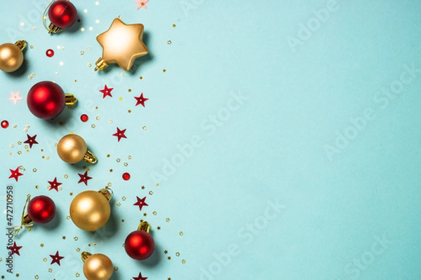 Fototapeta Christmas decorations on blue. Red and golden decor. Flat lay image with copy space.