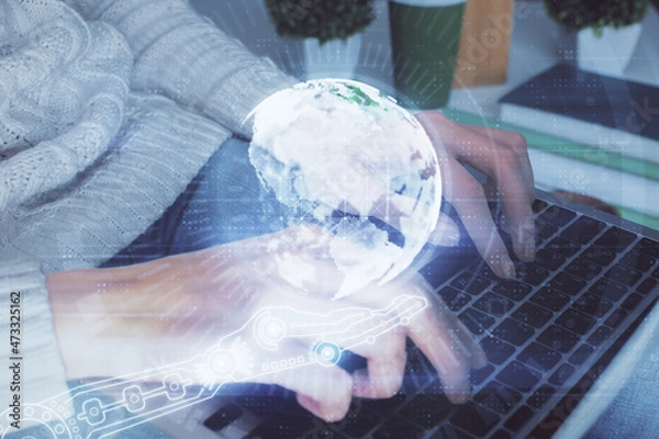 Fototapeta Double exposure of woman hands working on computer and world map hologram drawing. International technology business concept.