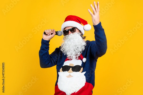 Fototapeta happy bearded man in santa claus hat and knitted sweater with microphone celebrate new year winter holiday, christmas carols