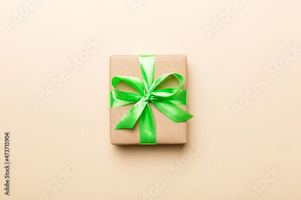 Fototapeta Holiday present box over colored background, top view. Copy space for design