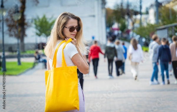 Fototapeta Young beautiful woman with linen eco bag on city background.