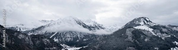 Fototapeta Amazing mystical rising fog forest snow snowy trees landscape snowscape in the mountains winter, Germany Allgäu panorama banner - dark mood in the alpine alps..