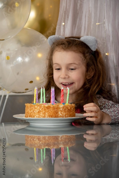 Fototapeta A cute little girl with the cake. House. Birthday. Atmosphere.