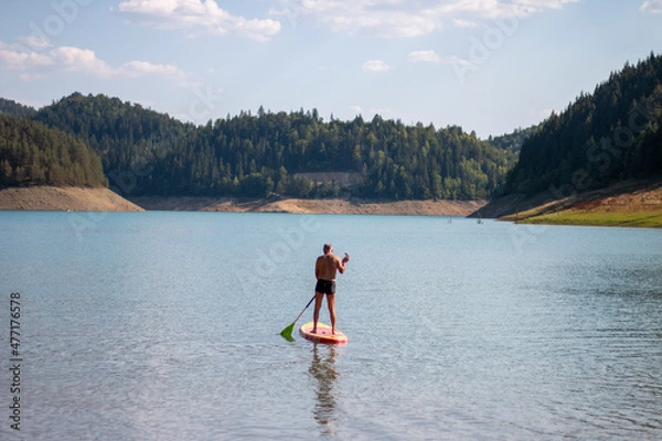 Fototapeta Active senior paddles a kayak at Zaovine Lake