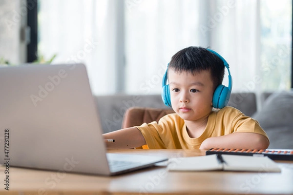 Fototapeta Asian boy student learning online learning online education video call .Happy boy study online with laptop at home. New normal life. Covid-19 or coronavirus. Social distancing. stay at home.