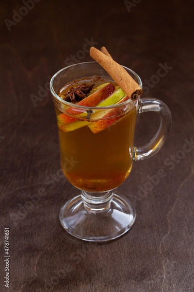 Fototapeta apple cider with apple and honey. Hot fruit tea with spices: cinnamon, cardamon, anise on the wooden table. Christmas drinks.top view. mulled wine. vertical