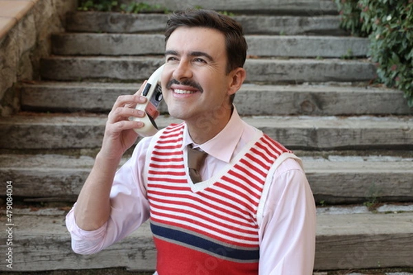 Fototapeta Businessman with a mustache using vintage walkie talkie