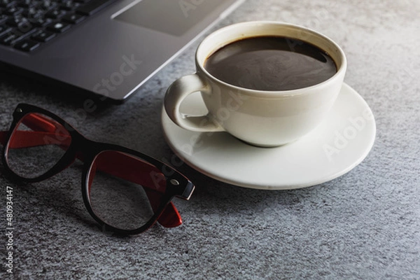 Fototapeta Coffee cup on desk with laptop and glasses