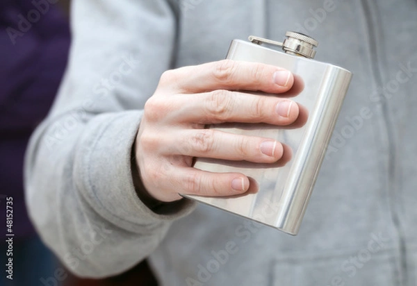 Fototapeta Closed steel small flask in man's hand