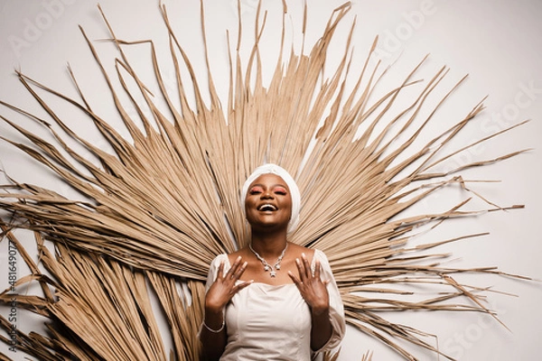 Fototapeta Portrait of black business lady on the dry leaves background. African model is posing in studio.