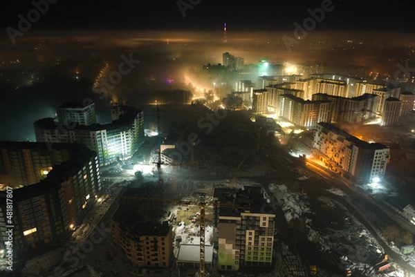 Fototapeta Aerial view of high rise apartment buildings and bright illuminated streets in Ivano-Frankivsk city, Ukraine residential area at night. Dark urban landscape