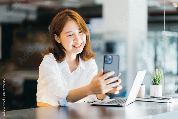 Fototapeta Hi nice to meet you. Joyful Asian young lady having a video call with a smart phone.