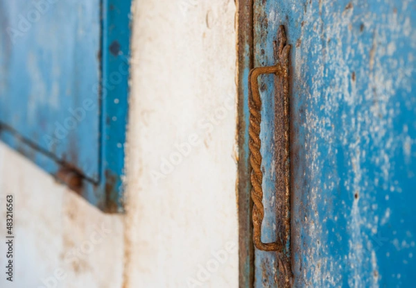 Fototapeta Old and rusty metal door handle of an old structure.