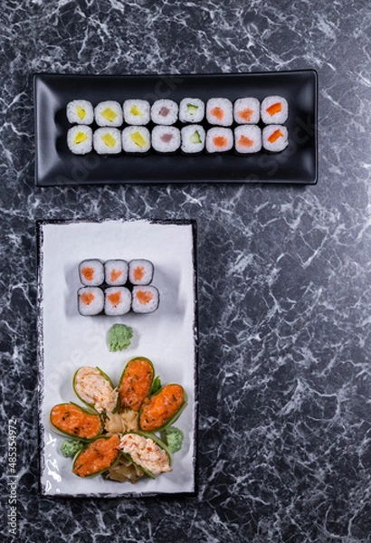 Fototapeta set of sushi rolls with seafood on a black stone background