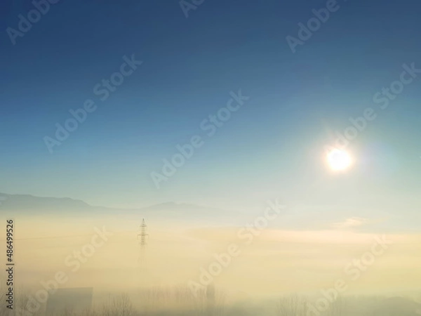 Fototapeta fog sun sunrise in the morning electric pylong electricity in stavraki villge ioannina perfecture greece