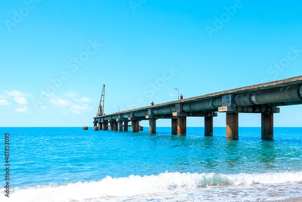 Fototapeta seascape on the coast, blue sea and blue sky, old pier on the horizon