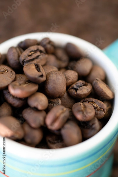 Fototapeta Coffee beans in an espresso cup macro close up