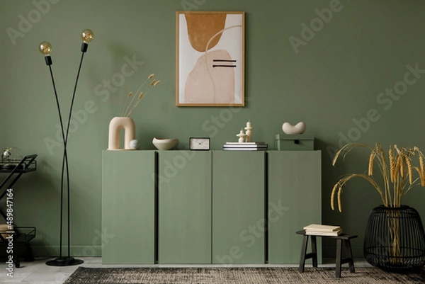 Fototapeta Modern living room interior composition with mockup poster frame, sage green wooden commode and modern home accessories. Eucalyptus wall. Home staging. Template. Copy space..