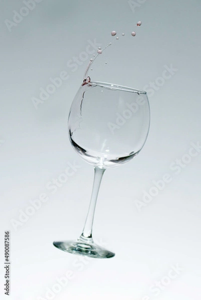 Fototapeta Drops of wine flying out of a glass