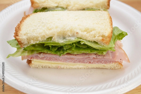 Fototapeta Close Up of a Half of a Ham Sandwich with Cheese, Mayonnaise, and Lettuce 