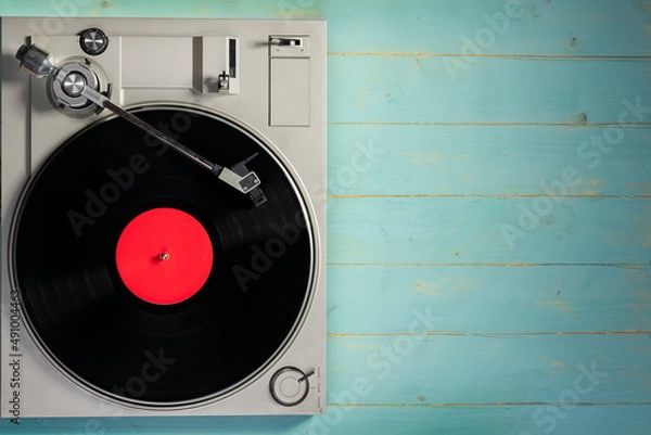 Fototapeta Old gramophone with a vinyl record on rustic wooden table, top view.