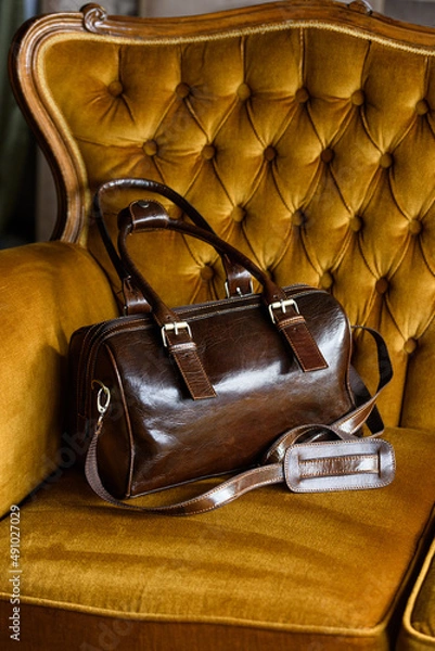 Fototapeta close-up photo of brown leather bag on a vintage sofa