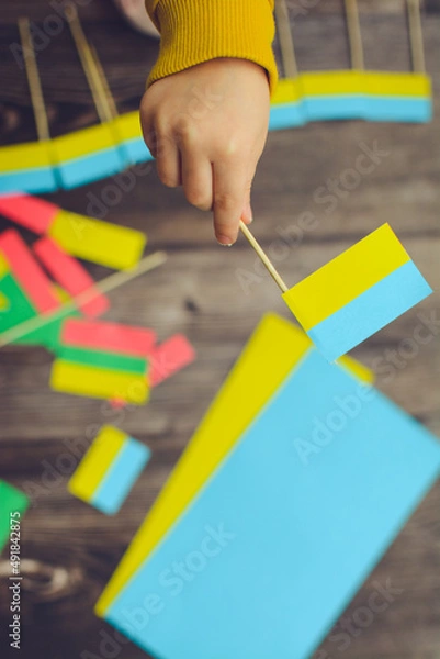 Fototapeta Kids are making small paper flags of Ukraine and Lithuania