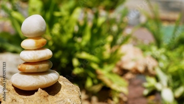 Fototapeta The Balance Stones are stacked as pyramids in a soft natural bokeh background, representing the calm philosophical concept of Jainism's wellness.