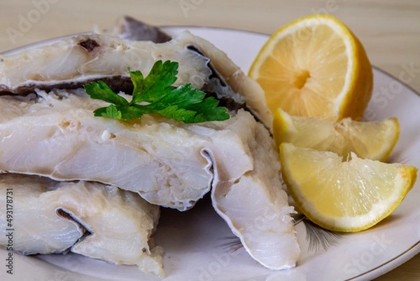 Fototapeta dish with pieces of fresh cod on wood