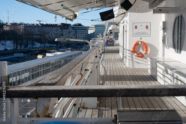 Fototapeta Closeup of a liferaft of a large passeger ferry. An outside walking promeade of a cruise ship.