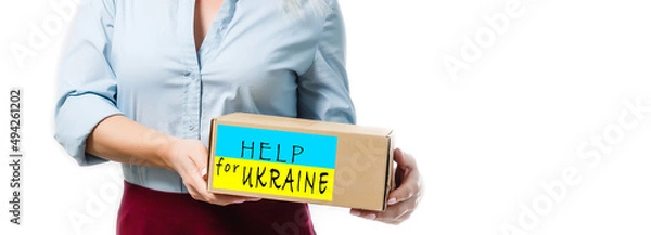 Fototapeta A man holds a box of aid for Ukrainian refugees and poor citizens who find themselves in a war between Ukraine and Russia. Humanitarian aid concept. Donate for refugees.