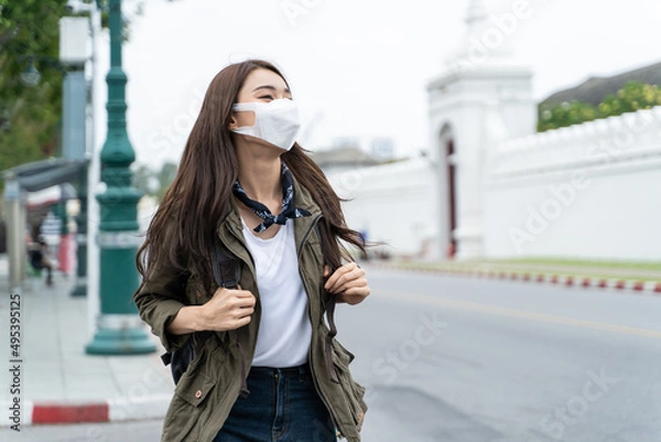 Obraz Asian attractive woman backpacker wear protective mask, walk in city. 