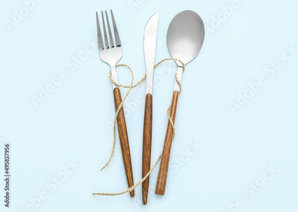 Fototapeta Elegant cutlery with rope on blue background