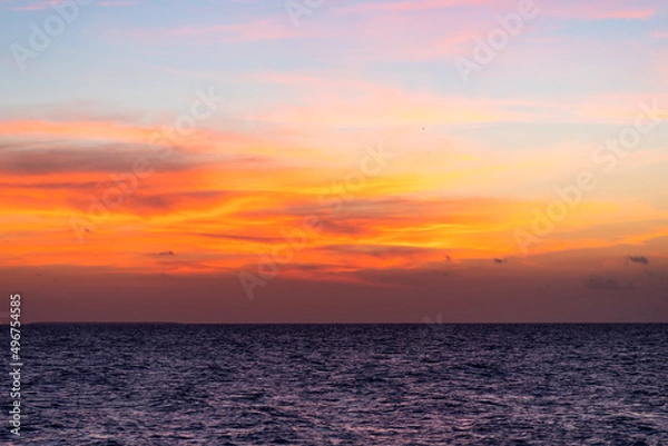 Fototapeta Beautiful view of the sea and the sky in the clouds at sunset. Orange red dawn, dusk on the sea coast