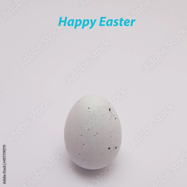 Fototapeta Easter white egg with black spots with copy space on a white background with text. Minimal Easter composition.