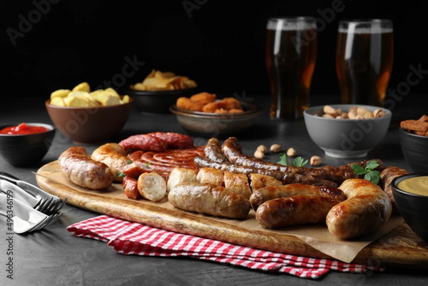 Fototapeta Set of different tasty snacks on dark grey table