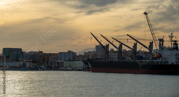 Fototapeta Cranes in the harbor at sunset