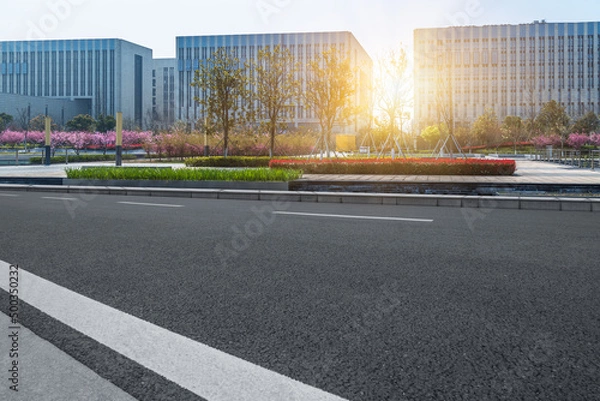 Fototapeta city empty traffic road with cityscape in background.