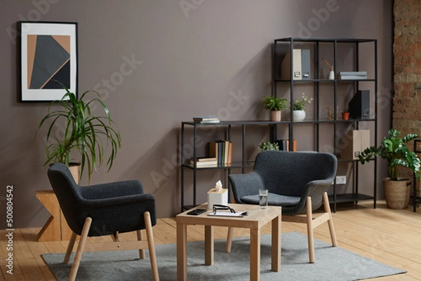 Fototapeta Horizontal no people shot of modern psychologist office interior in gray and brown colors with two chairs and coffee table