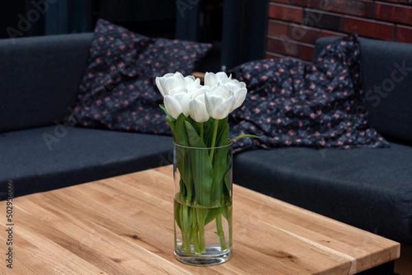 Fototapeta Empty table with flowers in outdoor cafe or restaurant. Sidewalk cafe. Touristic setting, tulips on cafe table, sidewalk cafe furniture.