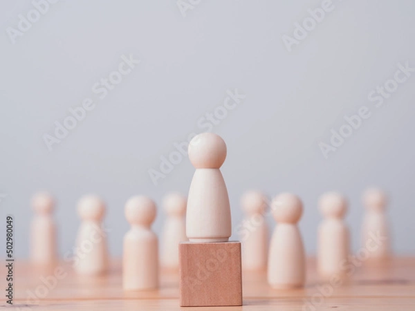 Fototapeta Concept of leadership, lead, inspire, empower, business, manager, teamwork, vision, strategy, influence, competition. Wooden doll or figure standing on wooden cube leading the team