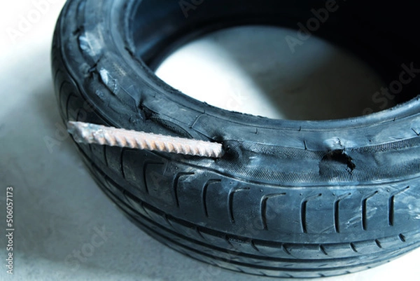 Fototapeta A car tire is pierced with metal reinforcement. Close-up. selective focus